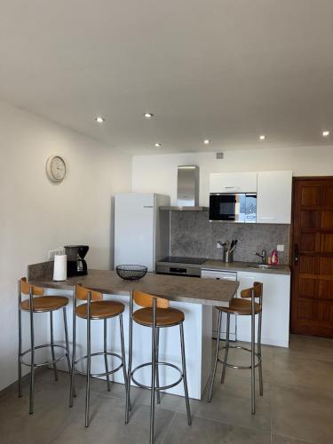 - une cuisine avec un comptoir et des tabourets dans l'établissement Appartement sur la plage, à Casaglione