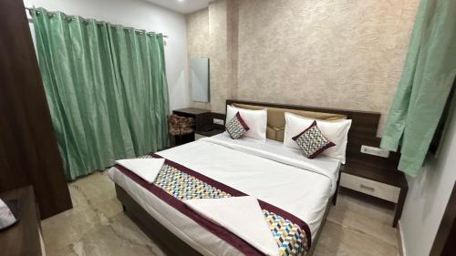 a bedroom with a large bed with green curtains at SANIDHYAM by HOTEL SAHU Near Kashi Vishwanath Temple Gate in Varanasi