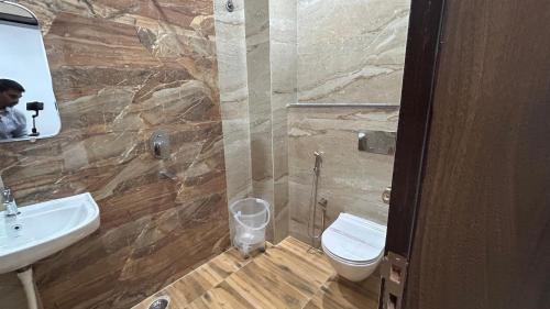 a bathroom with a toilet and a sink at SANIDHYAM by HOTEL SAHU Near Kashi Vishwanath Temple Gate in Varanasi