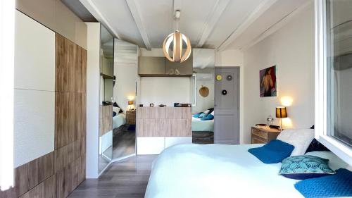 une chambre avec un grand lit blanc avec des oreillers bleus dans l'établissement villa 4ch 2 Sdb vue imprenable, à Fréjus