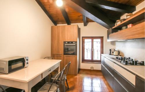 a kitchen with a counter and a table with a microwave at Nice Home In Fraz Azzida With Wifi in Azzida