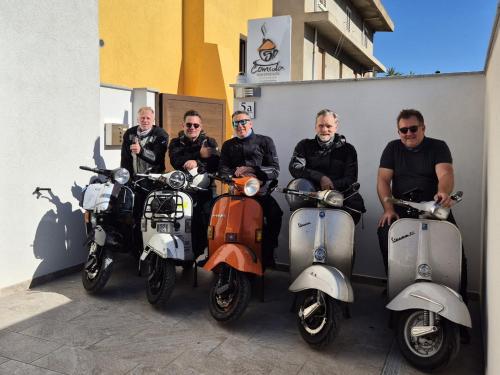 a group of men sitting on their scooters at COMIDA Guesthouse & Experiences in Tortolì