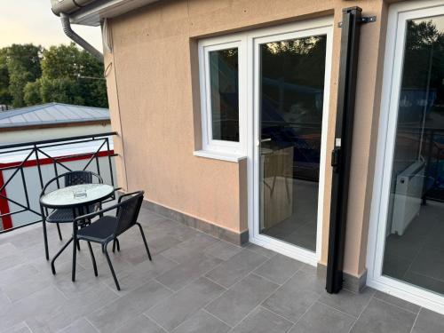 a patio with a table and chairs on a balcony at Laguna apartman Bogács in Bogács