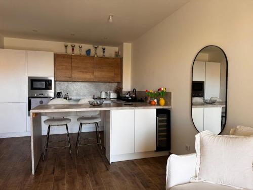 a kitchen with a counter with stools and a mirror at Appartement neuf, proche des plages et centre ville in Saint-Florent