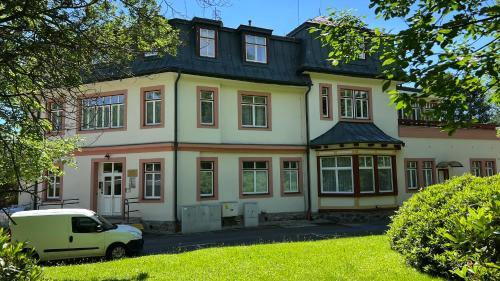 a van parked in front of a large house at Mountain Peak Apartment in Tatranská Lomnica