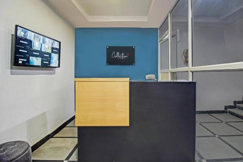 an office with a blue wall and a reception desk at Hotel O Qualia Miyapur in Hyderabad
