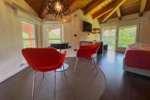 a living room with red chairs and a table at Trilogy San Giovanni in Torre Canavese