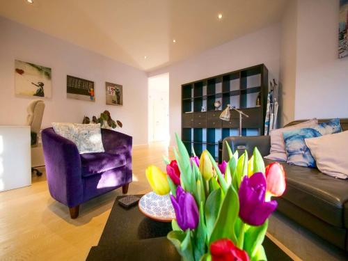 ein Wohnzimmer mit einem Sofa und einer Vase aus Blumen in der Unterkunft Apt w Garden Oasis in Finchley in Hendon