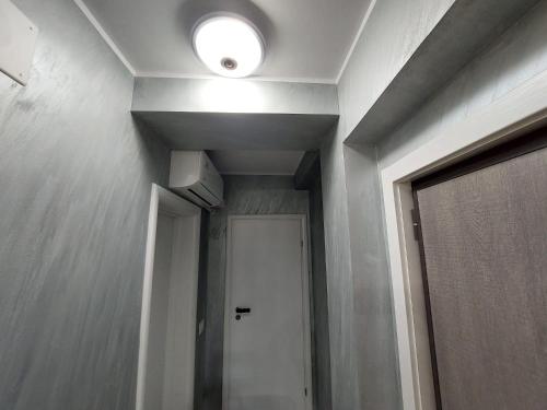 a hallway with a door and a light on the ceiling at Garsoniera in Vila Campus Constanta - New Building! in Constanţa