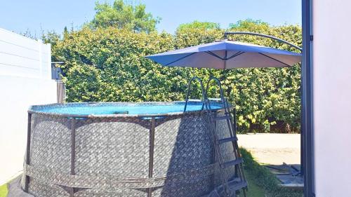 une cage avec un parapluie et une piscine dans l'établissement La Villa Grenadine, à Les Matelles