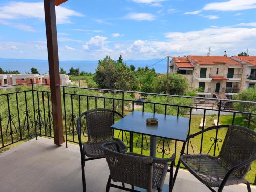 a patio with a table and chairs on a balcony at Kiparissis Apartments in Kriopigi