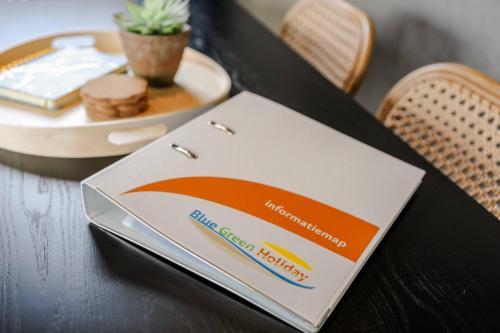 a laptop on a table with a plate of food at Luxe chalet op minicamping in waarde in Waarde