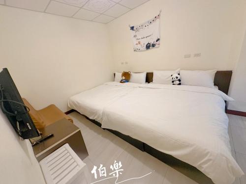 a bedroom with a bed and a desk with a tv at 伯樂休閒旅店 Bole Leisure Hotel in Yuchi