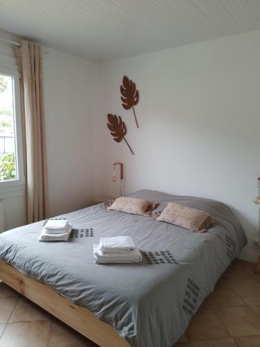 une chambre avec un lit avec deux serviettes dessus dans l'établissement Chalet entre océan et foret au calme, à Ondres