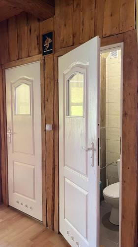a bathroom with two doors and a toilet at Zacisze Ośmiu Stawów Siekierczyna - The Quort of Eight Pounds 