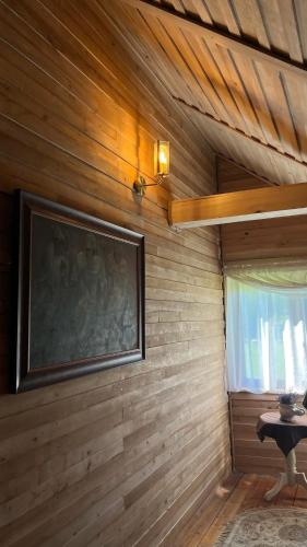 a room with a wooden wall with a large television at Zacisze Ośmiu Stawów Siekierczyna - The Quort of Eight Pounds 
