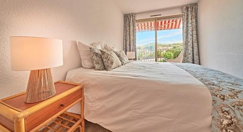 une chambre avec un lit et une table avec une lampe dans l'établissement Nouveau-La Florida - 4 personnes - 2 chambres - Saint-Tropez, à Saint-Tropez