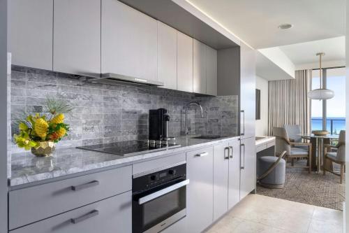 a kitchen with white cabinets and a counter top at The Ritz-Carlton Residences, Waikiki Beach Hotel in Honolulu