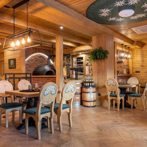 a restaurant with wooden walls and tables and chairs at Villa Adamo & Relax in Zakopane