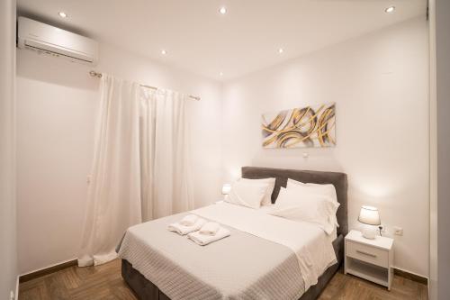 a white bedroom with a bed with two towels on it at Kyra's Luxury Suites 4 in Chios