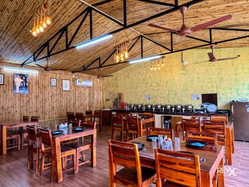 a restaurant with wooden tables and chairs and a bar at Euphoric Tiger Resort in Rishīkesh