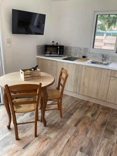 une cuisine avec une table, des chaises et un évier dans l'établissement Le Clos qui Clôt, à Le Fenouiller