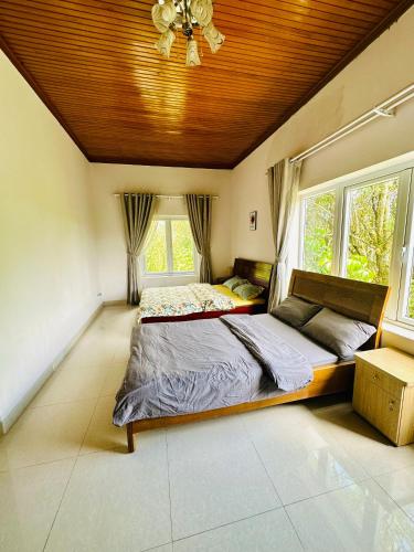 a bedroom with a large bed with a wooden ceiling at Jakaranda Villa Dalat in Da Lat