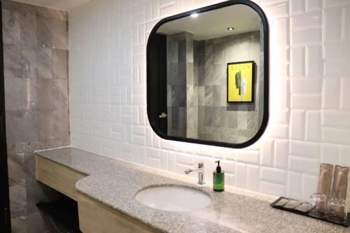a bathroom with a sink and a mirror at The Quarter Saphankhwai by UHG in Bangkok