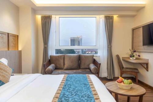 a bedroom with a bed and a couch and a window at Hotel Grand Eureka Near Delhi Airport in New Delhi