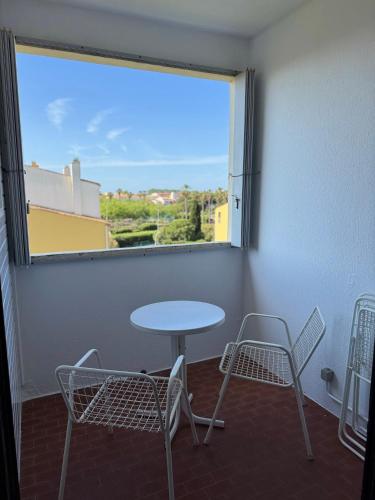 une table et des chaises dans une pièce avec une fenêtre dans l'établissement Appartement Confort-Terrasse-Parking-Wifi-Cap d'agde, au Cap d'Agde