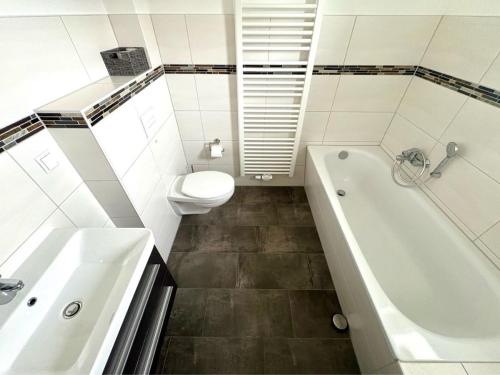 a bathroom with a tub and a toilet and a sink at Villa Weißer Schwan in Trent