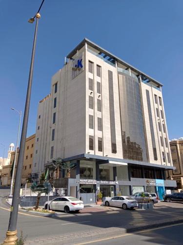 ein großes Gebäude mit davor geparkten Autos in der Unterkunft شقق كيان للشقق المخدومة in Abha