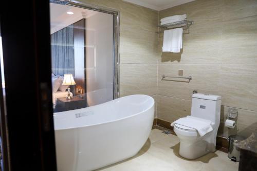 a bathroom with a bath tub and a toilet at فندق اهلا Hola Hotel in Al Jubail