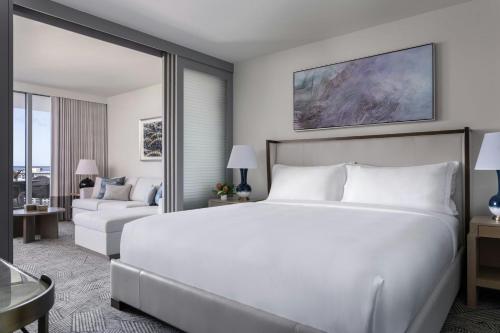 a bedroom with a large bed and a living room at The Ritz-Carlton Residences, Waikiki Beach Hotel in Honolulu