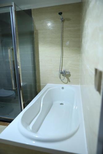 a white bath tub in a bathroom with a shower at فندق اهلا Hola Hotel in Al Jubail