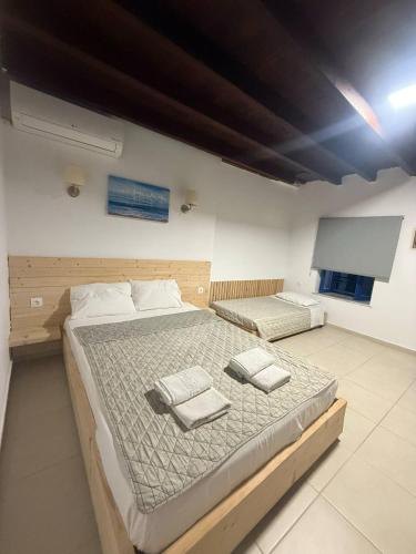 a bedroom with two beds and a flat screen tv at Occasus Room Comfort in Halki