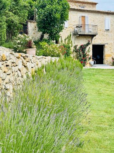 a stone wall in front of a house at L Ostau de la Treille in Limans