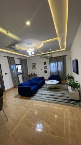 Una sala de estar con sofás azules y una mesa. en Cozy, Elegant, Central, Peaceful, en Cotonou