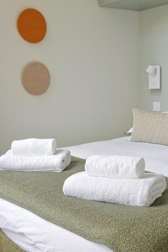 2 serviettes blanches assises au-dessus d'un lit dans l'établissement La Belle Endormie - Centre Ville - Elégant, à Bordeaux