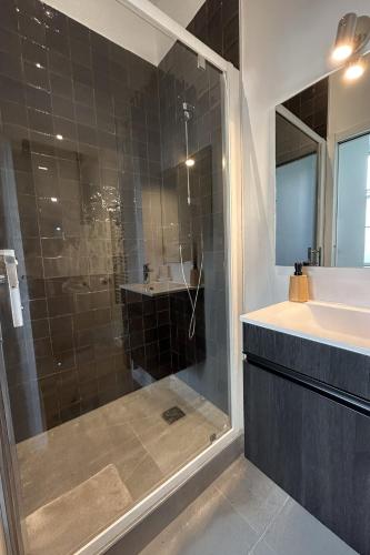 une salle de bain avec une douche en verre et un lavabo dans l'établissement La Belle Endormie - Centre Ville - Elégant, à Bordeaux