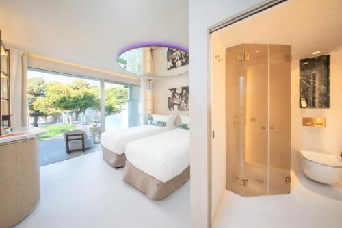 a bedroom with a bed and a bathroom at Destino Five Ibiza - 5-Star Grand Luxe Resort in Talamanca