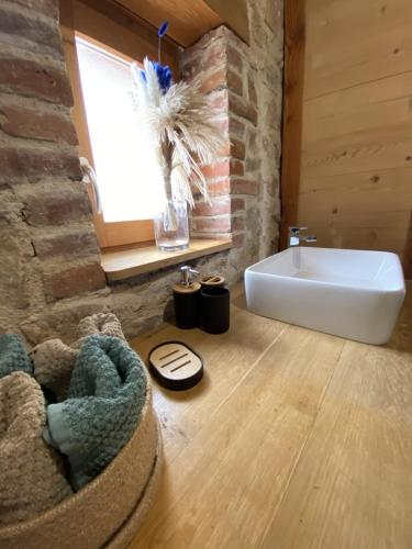 une salle de bain avec un lavabo blanc et une fenêtre dans l'établissement Le fournil, à Saint-Didier-sur-Rochefort
