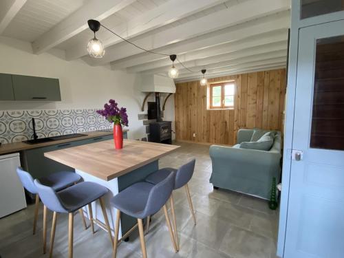 une cuisine avec une table en bois et des chaises bleues dans l'établissement Le fournil, à Saint-Didier-sur-Rochefort
