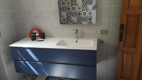 a bathroom with a white sink with a red handset at Villa Maria in Maruggio