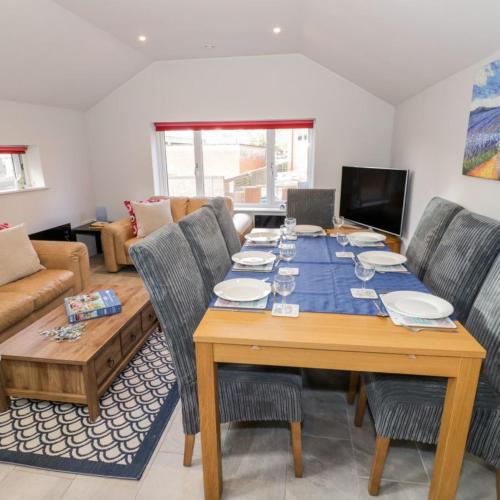 a dining room with a table with chairs and a couch at Entire cottage close to Coventry City Centre with 4 en suite bedrooms and gated parking in Coventry