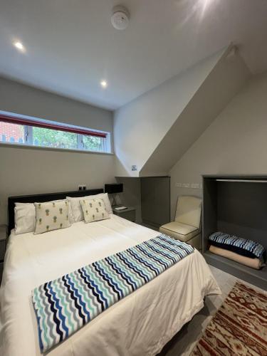 a bedroom with a large bed and a window at Entire cottage close to Coventry City Centre with 4 en suite bedrooms and gated parking in Coventry