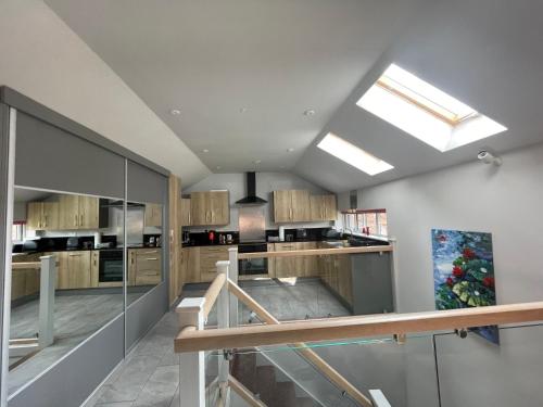 a kitchen with wooden cabinets and a skylight at Entire cottage close to Coventry City Centre with 4 en suite bedrooms and gated parking in Coventry