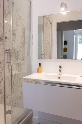 une salle de bain blanche avec un lavabo et une douche dans l'établissement La Suite des Martyrs - Centre Ville - Elégant, à Bordeaux