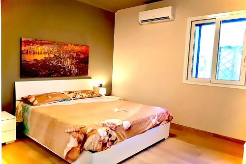 a bedroom with a bed and a painting on the wall at Villa Tea con piscina a pochi passi dal mare in Fontane Bianche