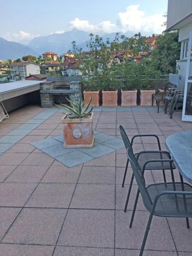 a patio with tables and chairs and a potted plant at Res Roncaccio, Bilancia by HolAp SA in Vairano